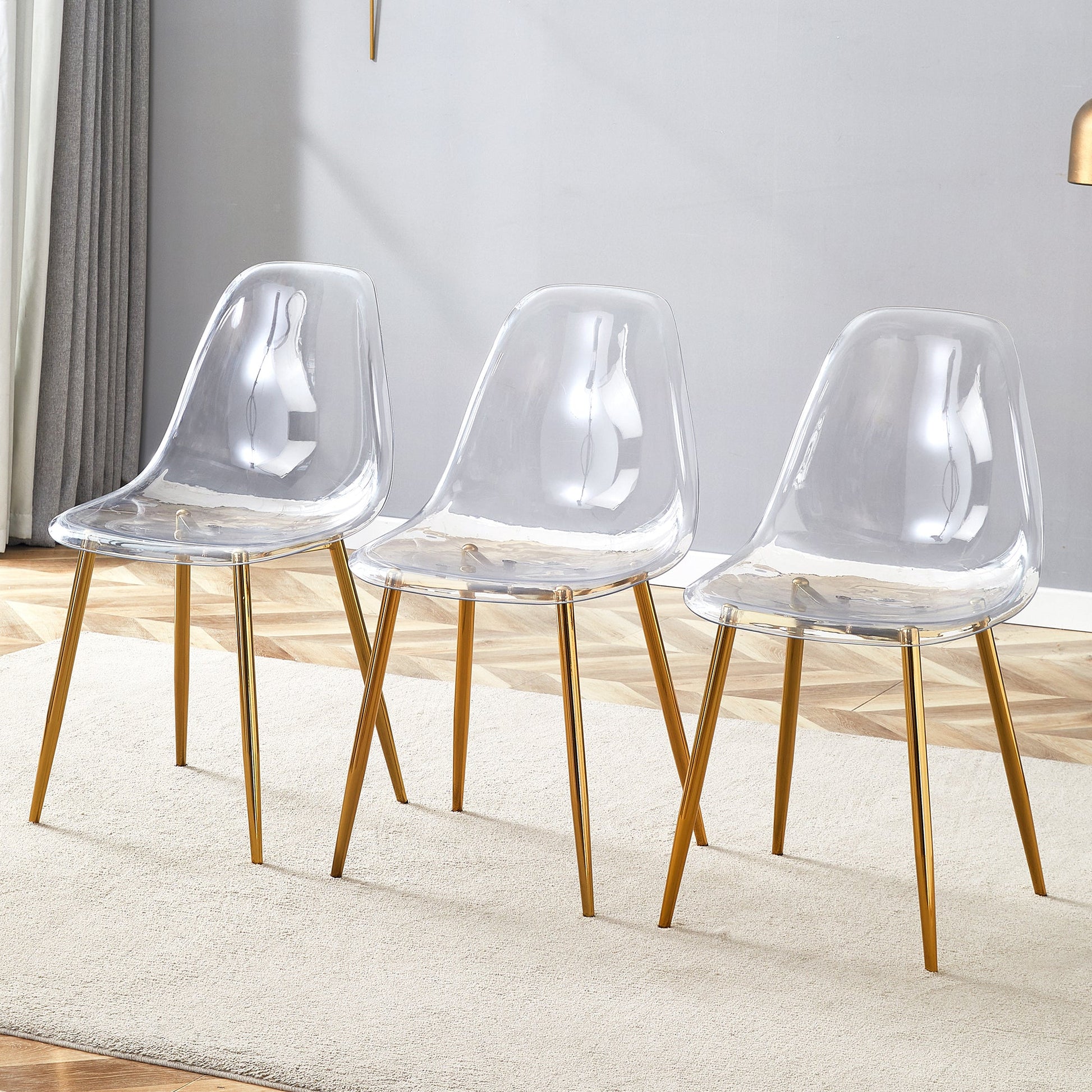 Transparent and stylish ergonomic dining chair unlocks a new experience of lightweight fashion, comfort, and stability. Transparent seat cushion, golden metal legs. One box of three. SolidRoot Buy Furniture USA